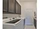 Bright laundry room with cabinets and plenty of space at 5112 Coastal Scene Dr, Apollo Beach, FL 33572