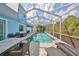 Inviting pool area with screened enclosure, patio furniture, and lush landscaping at 5112 Coastal Scene Dr, Apollo Beach, FL 33572