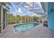 Inviting screened pool with paved patio, outdoor kitchen, and lush landscaping at 5112 Coastal Scene Dr, Apollo Beach, FL 33572