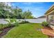 Landscaped backyard with grassy area and wooden fence at 121 Lacewing Pl, Valrico, FL 33594