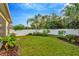 Landscaped backyard with lush greenery and a white privacy fence at 121 Lacewing Pl, Valrico, FL 33594