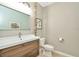 Modern bathroom with single sink vanity, toilet and decorative driftwood at 121 Lacewing Pl, Valrico, FL 33594