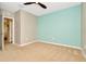 Light and airy bedroom with gray and teal walls, carpet, and door to hallway at 121 Lacewing Pl, Valrico, FL 33594