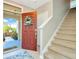 Bright and airy entryway with a red door and staircase leading upstairs at 121 Lacewing Pl, Valrico, FL 33594