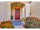 Inviting front entry with a red door, lush landscaping, and a welcoming wreath at 121 Lacewing Pl, Valrico, FL 33594