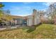 Backyard with a chimney, screened patio, air conditioning condenser, and green grass at 10113 Tarragon Dr, Riverview, FL 33569