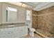 Bathroom featuring granite counters, white cabinets, and tiled shower at 10113 Tarragon Dr, Riverview, FL 33569