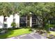 Condo building surrounded by mature trees and green lawns at 1398 Shady Pine Way # H3, Tarpon Springs, FL 34688