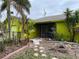 Bright yellow single story home with tropical landscaping and fenced yard at 1401 Bay Palm Blvd, Indian Rocks Beach, FL 33785