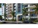 Building entrance with parking and tropical landscaping at 411 E Shore Drive # 705, Clearwater Beach, FL 33767