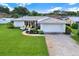 White single-story home with attached garage, landscaping, and driveway at 14542 Anchorage Cir, Seminole, FL 33776