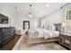 Spacious main bedroom with white walls, wood floors, chandelier, and large comfortable bed at 2527 W Maryland Ave # A, Tampa, FL 33629