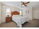 Well-lit bedroom with ceiling fan, wood furniture and carpet floors at 613 79Th S Cir, St Petersburg, FL 33707