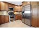 Modern kitchen with stainless steel appliances and wood cabinets at 613 79Th S Cir, St Petersburg, FL 33707