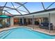 Inviting pool and spa with a screened enclosure, offering privacy and shade at 613 79Th S Cir, St Petersburg, FL 33707