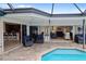 Relaxing pool area with covered patio, plenty of seating, and access to kitchen at 613 79Th S Cir, St Petersburg, FL 33707