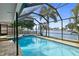 Spacious pool area with screened enclosure and hot tub, overlooking the water at 613 79Th S Cir, St Petersburg, FL 33707