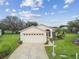 Single story house featuring a two-car garage and lush landscaping at 11609 Weaver Park Ct, Trinity, FL 34655