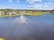 Aerial view of a lake with a fountain and homes at 11609 Weaver Park Ct, Trinity, FL 34655