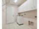 Bright laundry room with storage and tile floors at 11609 Weaver Park Ct, Trinity, FL 34655