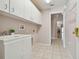 Laundry room with cabinets, sink, and tile floor at 11609 Weaver Park Ct, Trinity, FL 34655