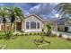 Tan one-story house with a two-car garage and lush landscaping at 10922 Brucehaven Dr, Riverview, FL 33578