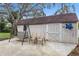 Backyard shed surrounded by lush greenery, with a swing and chairs at 1429 Monte Lake Dr, Valrico, FL 33596