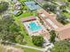 Aerial view of community amenities including a pool, tennis courts, clubhouse, and lush landscaping at 3157 Mission Grove Dr, Palm Harbor, FL 34684