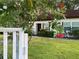 Charming single-story home with well-maintained lawn, blossoming trees, and a welcoming entrance at 3157 Mission Grove Dr, Palm Harbor, FL 34684