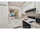 A bright kitchen with a pass-through to the dining area and white appliances and cabinets at 3157 Mission Grove Dr, Palm Harbor, FL 34684