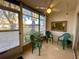 Enclosed lanai with tile flooring, three chairs, and a peaceful view of the community at 3157 Mission Grove Dr, Palm Harbor, FL 34684