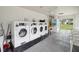 Clean and well-lit laundry room featuring multiple washers and dryers at 3157 Mission Grove Dr, Palm Harbor, FL 34684