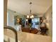 Open concept living and dining area with an elegant light fixture and sliding glass doors at 3157 Mission Grove Dr, Palm Harbor, FL 34684
