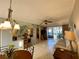 Comfortable living room features tile flooring, a ceiling fan, and access to the screened lanai at 3157 Mission Grove Dr, Palm Harbor, FL 34684