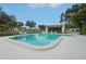 Community pool surrounded by lounge chairs and lush landscaping on a clear day at 3157 Mission Grove Dr, Palm Harbor, FL 34684
