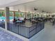 Inviting poolside seating area with ample tables and chairs under a covered patio with ceiling fans at 3157 Mission Grove Dr, Palm Harbor, FL 34684