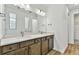 Modern bathroom boasts double vanity with dark brown cabinets and a large mirror at 1692 Fallon Pass, Zephyrhills, FL 33541