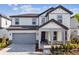 Two-story home with gray siding, gray roof, and a large gray garage door at 1692 Fallon Pass, Zephyrhills, FL 33541