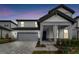 Two-story home with a gray garage and a covered entryway at 1692 Fallon Pass, Zephyrhills, FL 33541