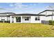 Back exterior view of house showcasing patio and lawn at 1692 Fallon Pass, Zephyrhills, FL 33541