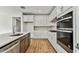 Modern kitchen with white cabinets, stainless steel appliances, and wood flooring at 1692 Fallon Pass, Zephyrhills, FL 33541