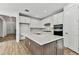 Modern kitchen with white cabinets, quartz countertops, and a large island at 1692 Fallon Pass, Zephyrhills, FL 33541