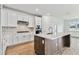 Modern kitchen with white cabinets, quartz countertops, and a large island at 1692 Fallon Pass, Zephyrhills, FL 33541