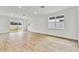 Spacious living room with wood-look tile flooring and sliding glass doors at 1692 Fallon Pass, Zephyrhills, FL 33541