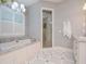 Spa-like bathroom with a soaking tub, walk-in shower, and marble flooring at 4923 W Melrose N Ave, Tampa, FL 33629