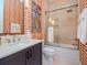 Stylish bathroom with modern vanity, glass shower, and orange patterned walls at 4923 W Melrose N Ave, Tampa, FL 33629