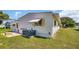 Side view of a manufactured home with AC unit and patio at 15 Hamilton Ln # 7, Palm Harbor, FL 34684