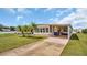 Single-wide manufactured home with carport and palm trees at 15 Hamilton Ln # 7, Palm Harbor, FL 34684