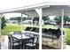 Community outdoor kitchen with grills and seating under a covered patio at 15 Hamilton Ln # 7, Palm Harbor, FL 34684