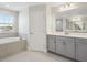 Modern bathroom with gray cabinets and a soaking tub at 3437 Yellow Leaf Cir, Spring Hill, FL 34609